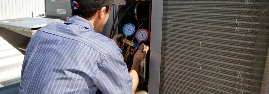 HVAC technician servicing a condenser unit in Sulphur Springs
