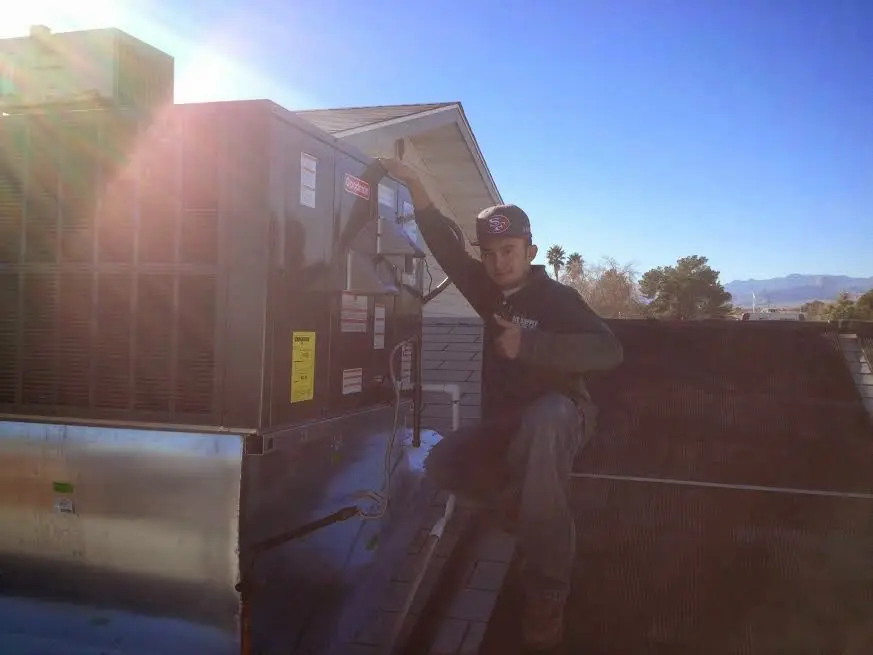 HVAC technician performing Boiler Repair on a rooftop unit in Sulphur Springs
